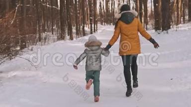 快乐的母亲和女儿在冬季森林中笑着跳着慢动作